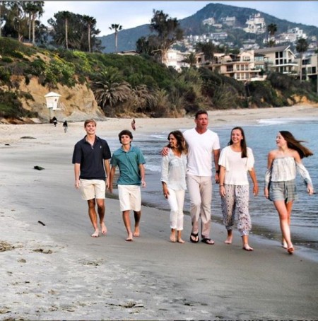 Catherine Mooty with Familyon a beach visiting walking together as a strongly bonded family.
